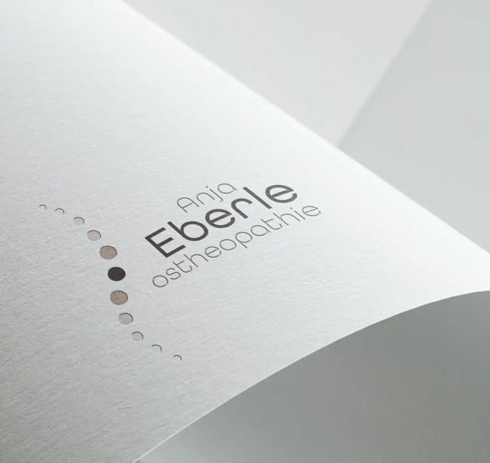 Logo von Anja Eberle Osteopathie, bestehend aus einer eleganten Schrift und einer Reihe von Kreisen in verschiedenen Brauntönen, die einen geschwungenen Bogen als Wirbelsäule bilden