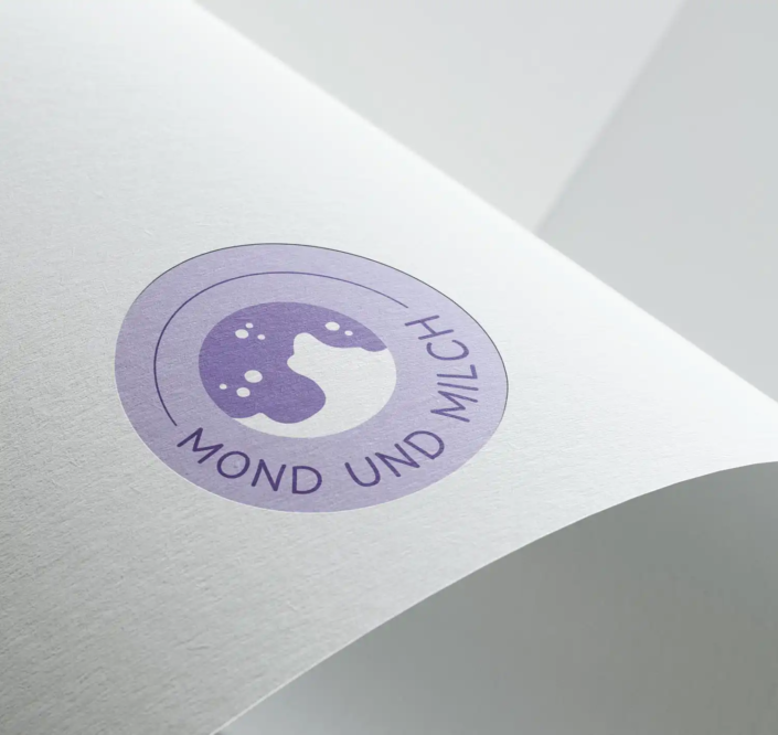 Logo von 'Mond und Milch' mit einem Halbmond und Milchspritzern in Lila